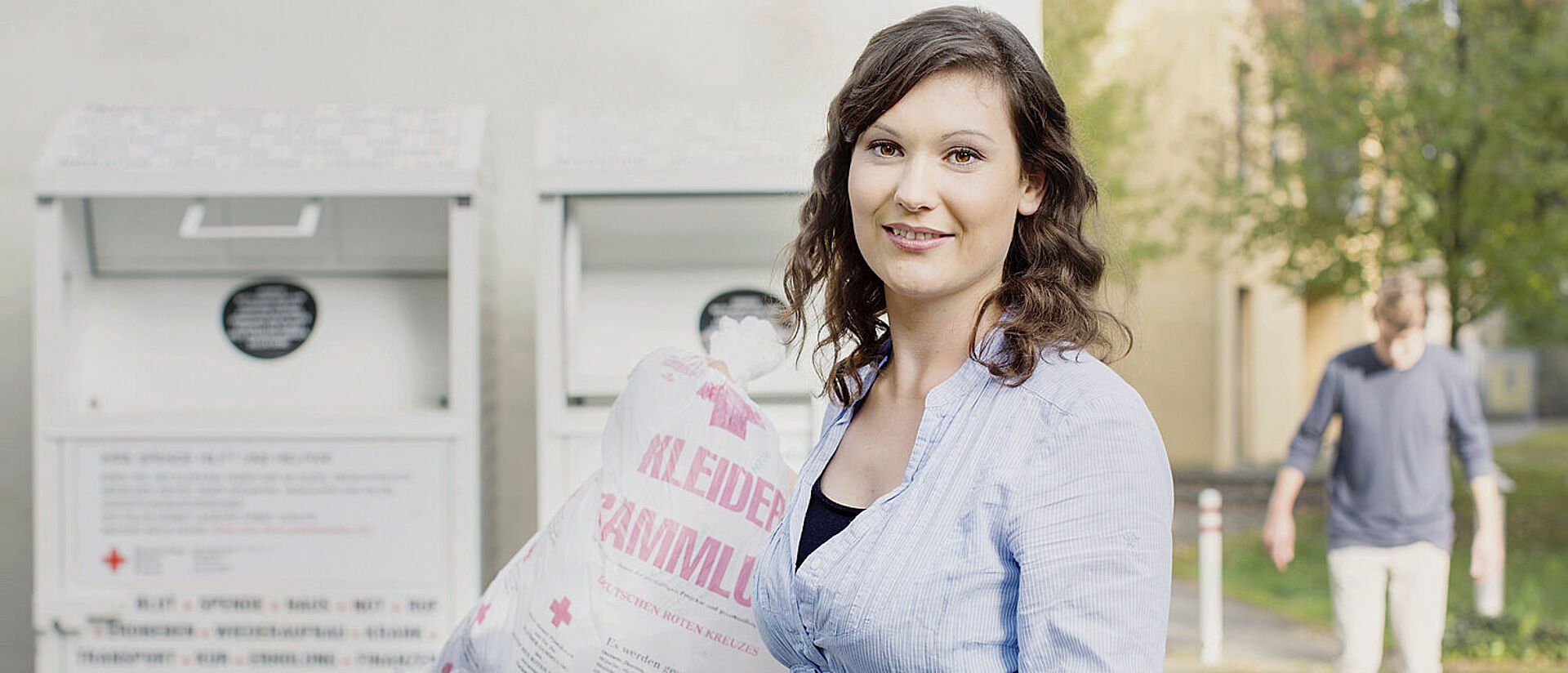 Kleidersammlung des DRK und Altkleidercontainer: junge Frau mit Altkleidersack vor einem Container des DRK- 2014 Kleidersammlung des DRK und Altkleidercontainer: junge Frau mit Altkleidersack vor einem Container des DRK- 2014